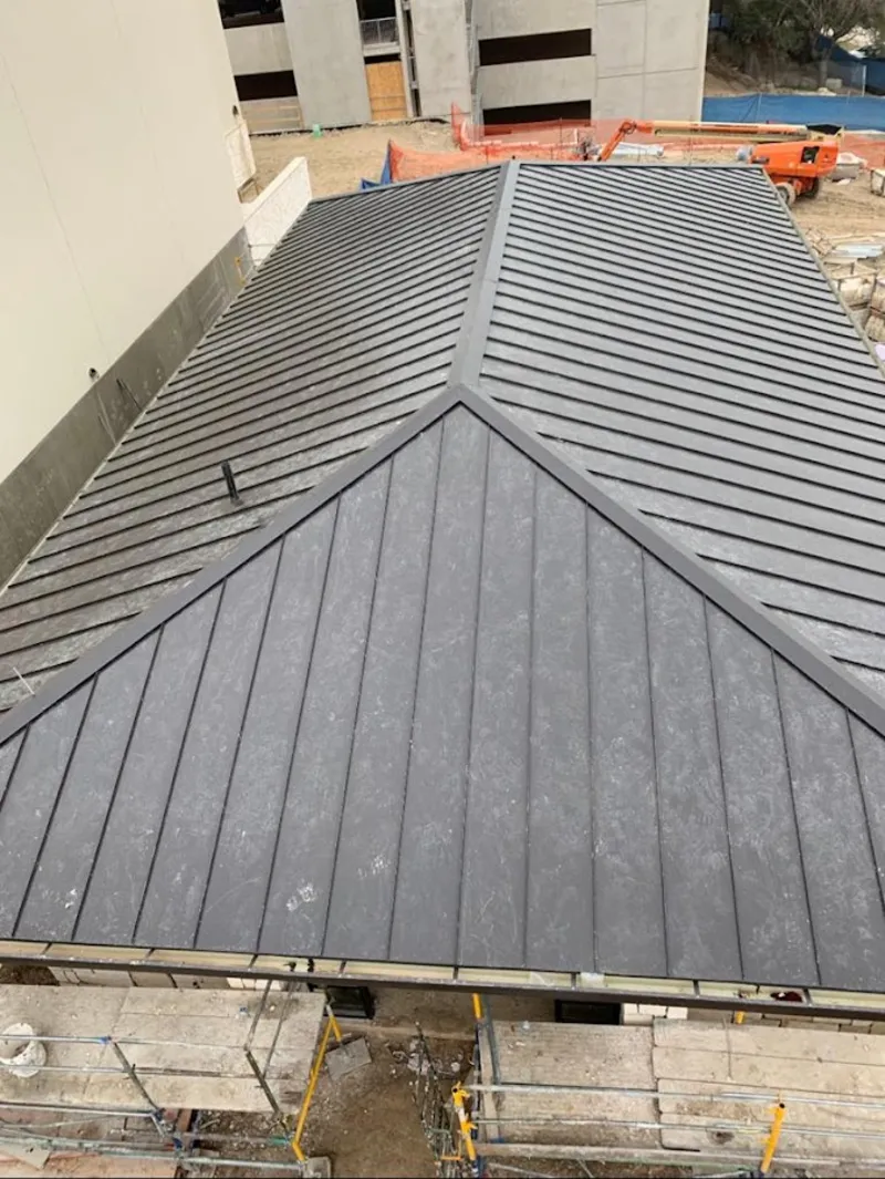 Commercial metal roof construction with crane equipment in Burlington